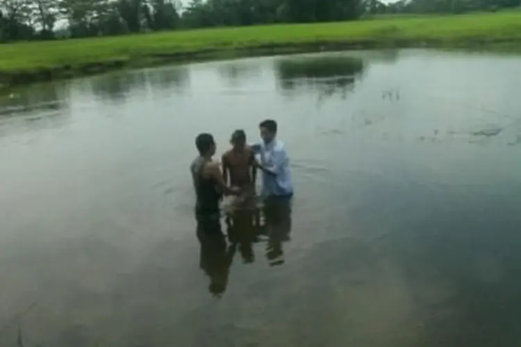 man being baptised in the river